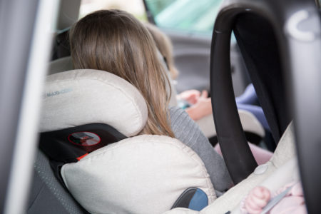 Drie kinderen in autostoelen op de achterbank 